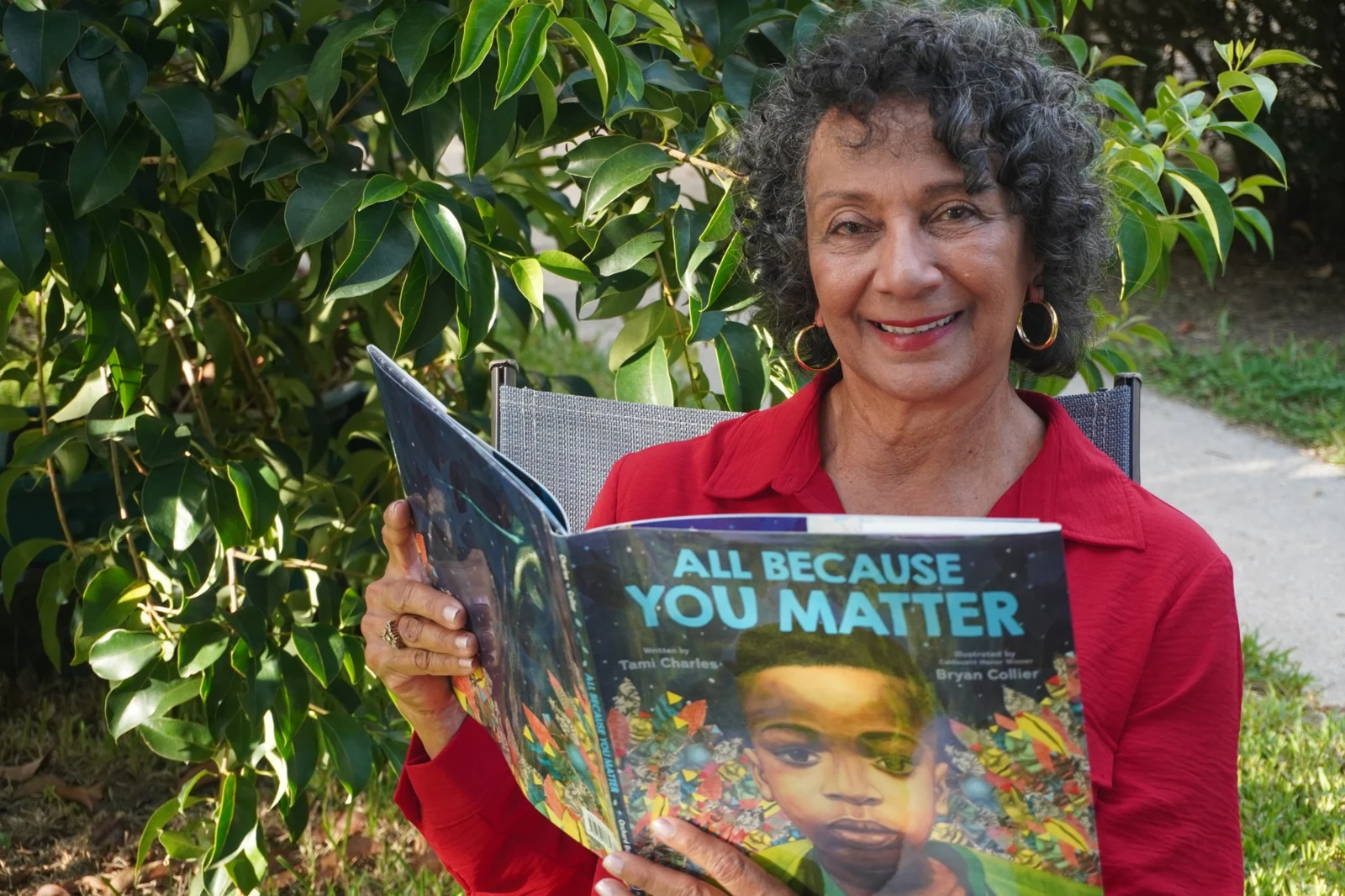 Stephenie Aubert reading a children's book outdoors